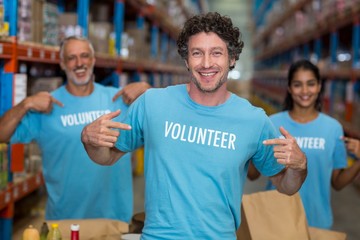 Portrait of volunteers pointing at t-shirt