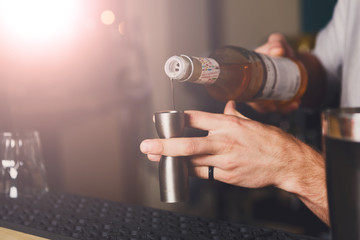 Barman's hands making shot cocktail