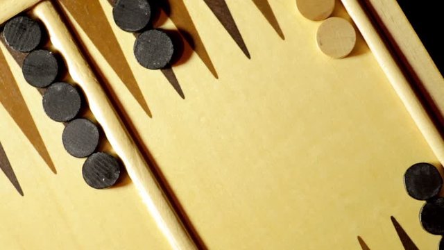 Panning shot of a backgammon board with dice, double six.