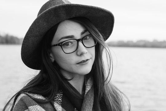 close portrait of a girl with glasses and hat at the lake