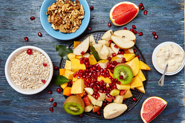 Fruits and berries for fruit salad. On blue rustic wooden background, top view. Copy space