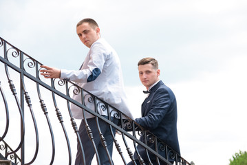 best man and groom standing on the balcony