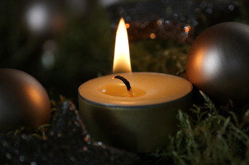 Teelicht im Moss umgeben von Weihnachtskugeln