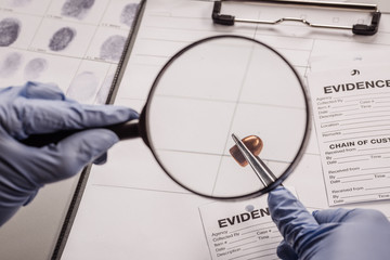 Detective through a magnifying glass looking at a evidence