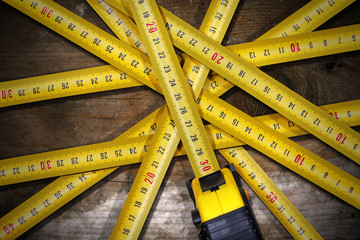 Group of Tape Measures on Wooden Table