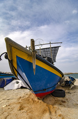closed up fisherman boat stranded on the sandy beach and cloudy sky at sunny day.