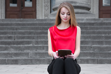 young beautiful woman using tablet outside