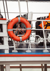 Lifebuoy and life jackets on a ferry deck close-up. Rescue equipment
