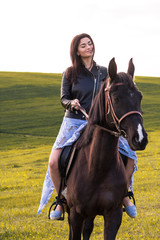 Obraz premium beautiful young woman riding a horse in a meadow