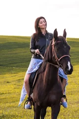 Foto op Canvas beautiful young woman riding a horse in a meadow © romanets_v