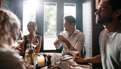 Young men and women having wine at restaurant