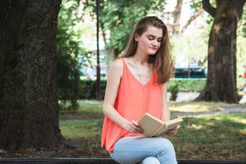 Slim young girl, sitting  and reading a book,  background, on th