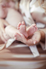 Obraz na płótnie Canvas Newborn Baby feet in mother hands closeup