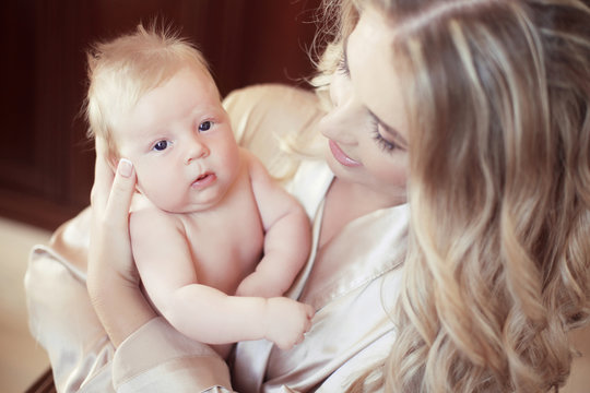 Adorable baby portrait. Happy beautiful mother holding her newbo
