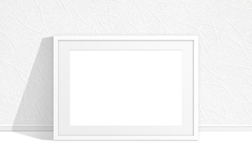 Blank photo frame near the wall with textured wallpaper