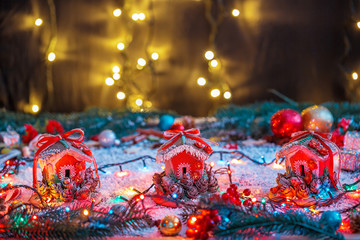 Christmas cookies Gingerbreads Houses with garlands and fir festive decoration with snow on blurred bokeh background. View with copy space