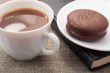 White cup with cocoa and chocolate biscuit