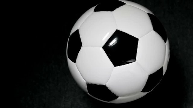 Soccer ball or football bright studio on a black background. video rotation