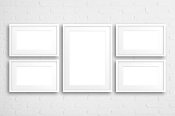 Blank  frames collage  on white bricks wall