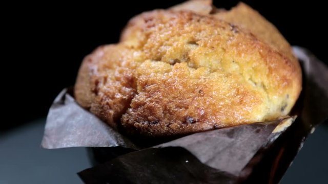 freshly baked muffin on a black background. video rotation