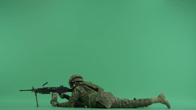 Soldier lying and targeting to the left at green screen