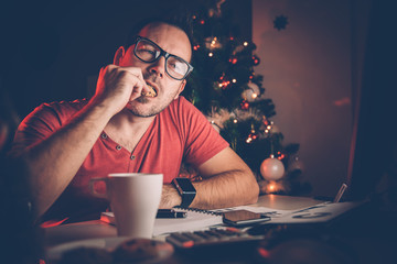 Man working late and eating cookie
