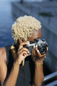 Young woman with camera taking pictures