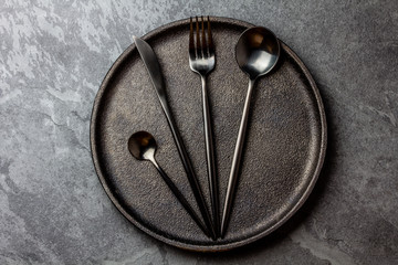 Cutlery set on plate. black table setting. Top view