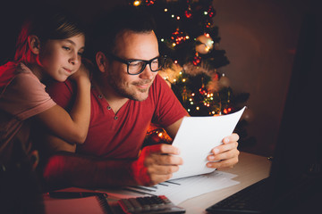 Father and daughter reading christmas wish list