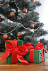 Christmas present on decorated tree background, holiday concept