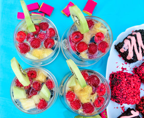 Champagne with fruit in a beautiful glass. Colorful Cakes on the occasion. Picnic table.

