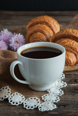 Breakfast. Coffee and croissants. Dark wood background. Vertical