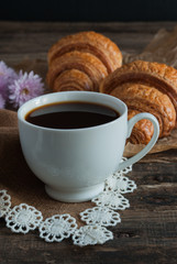 Breakfast. Coffee and croissants. Dark wood background. Vertical