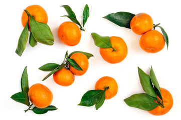 Fresh tangerines with green leaves in wooden bowl on a white bac