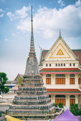 Fototapeta premium Stupa-like pagoda encrusted with coloured faience in Temple of Dawn, Wat Arun, Bangkok, Thailand.