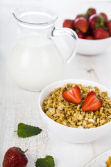  Muesli and a jug of milk for breakfast.Granola with strawberry