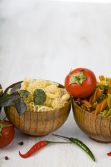 Fototapeta na wymiar Pasta and ingredients: chili, tomatoes, basil, garlic and parsle