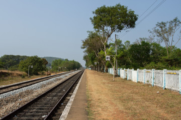 Fototapeta na wymiar Railway platform with a tree and white fence