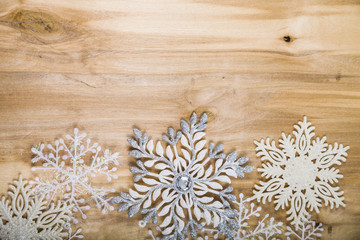 Silver snowflakes on a wooden table. Christmas decorations close