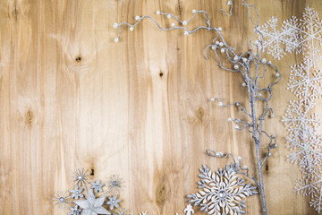 Silver snowflakes and decorative twig on a wooden table. Christm