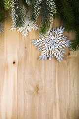 Silver snowflakes and fir branches on a wooden table. Christmas