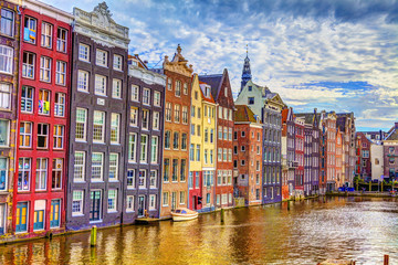 Buildings on the water in Amsterdam and cloudy skies, HDR Image. - obrazy, fototapety, plakaty