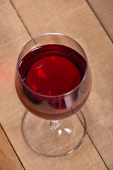 Wineglass with the red wine on the wooden table