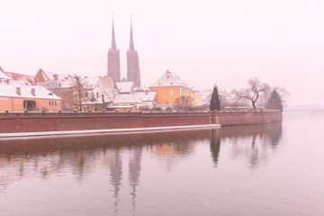 Cathedral Island or Ostrow Tumski with with Cathedral of St. John and church of the Holy Cross and St. Bartholomew in the snowy overcast winter day in Wroclaw, Poland