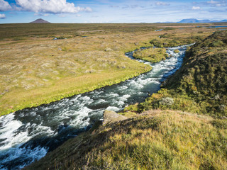 Blue river at green country in North Iceland