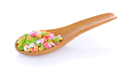 colorful candy in wood spoon on white background