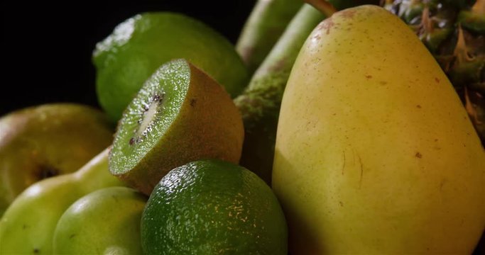 Still life green fruits composition rotation 4k looped video copy space. Close-up grocery food isolated on black background