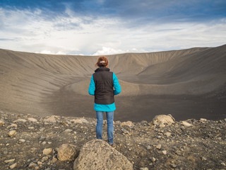 Back view of a woman in front of a volcano