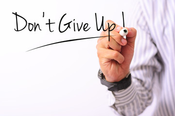 business concept image of a hand holding marker and write don't give up isolated on white