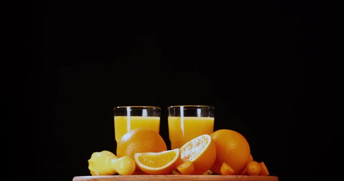 Still life citrus orange juice fruits composition rotation 4k looped intro video copy space. Drink glass grocery food isolated on black background